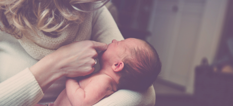 Mother Wearing Ring & Holding Newborn