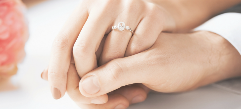 Woman's Hand Wearing Oval Cut Engagement Ring