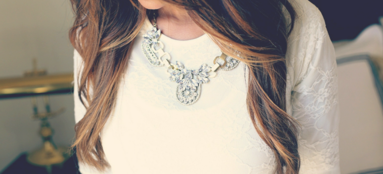 Young Woman in White Dress Wearing Statement Necklace